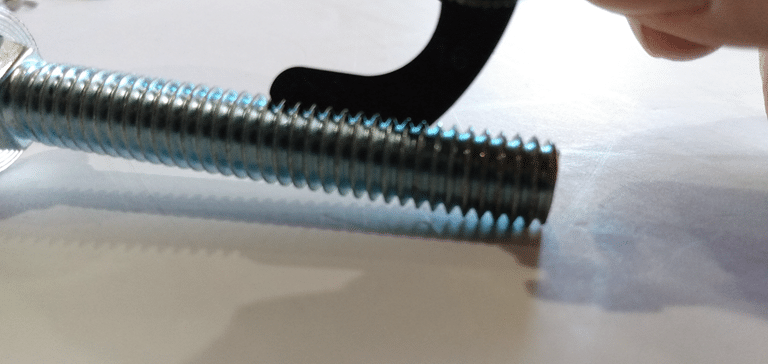 Original photo of thread feeler gauge fitting into the thread of a screw